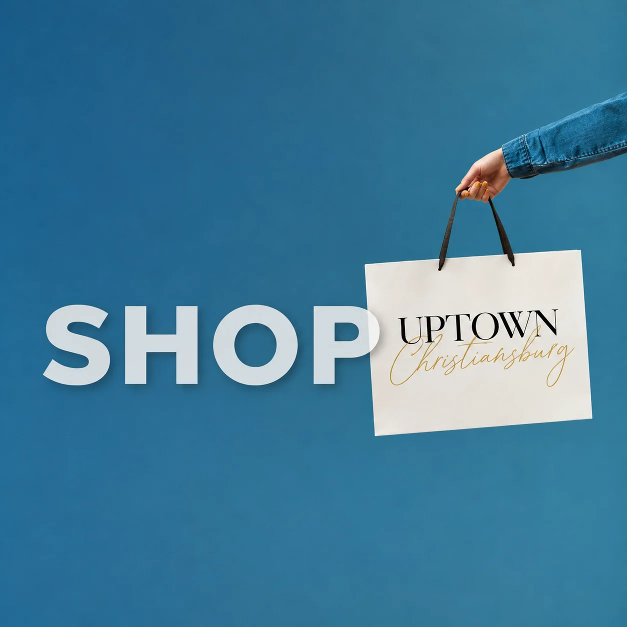 Shop Uptown Christiansburg: a hand holding an Uptown Christiansburg shopping bag